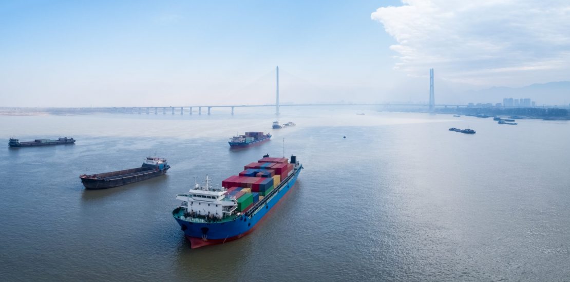 container ships on yangtze river , water transport concept container ships waiting to enter port at anchor on yangtze river with jiujiang cable-stayed bridge , water transport concept